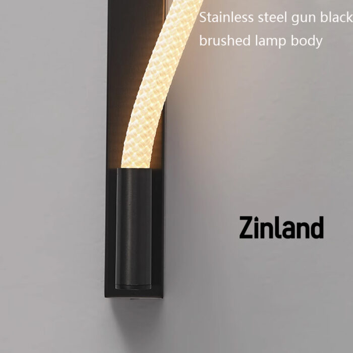 Modern LED wall light with a gun black brushed stainless steel body and a soft woven silicone light tube, providing warm and even illumination for indoor decorative lighting.