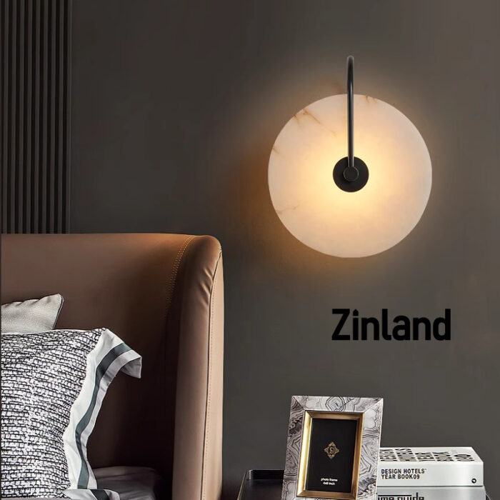 Luxury black alabaster wall lamp with a curved black metal arm, mounted beside a stylish leather bed for warm ambient lighting.